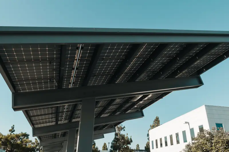 Carport couvert de panneaux solaires devant une maison